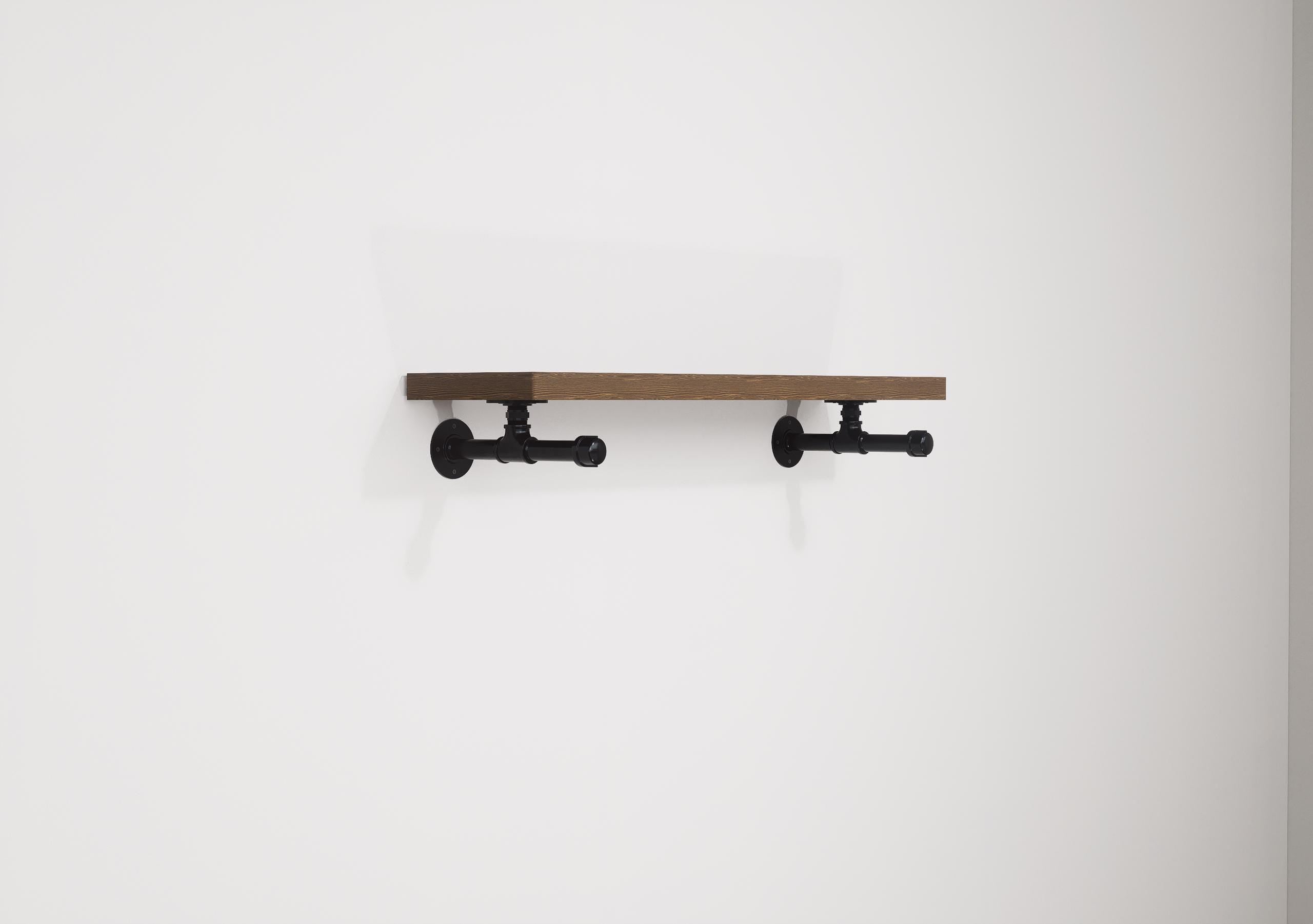 Wall-mounted industrial shelf with a wooden shelf and metal pipe fittings, featuring a hanging rail for clothes storage.