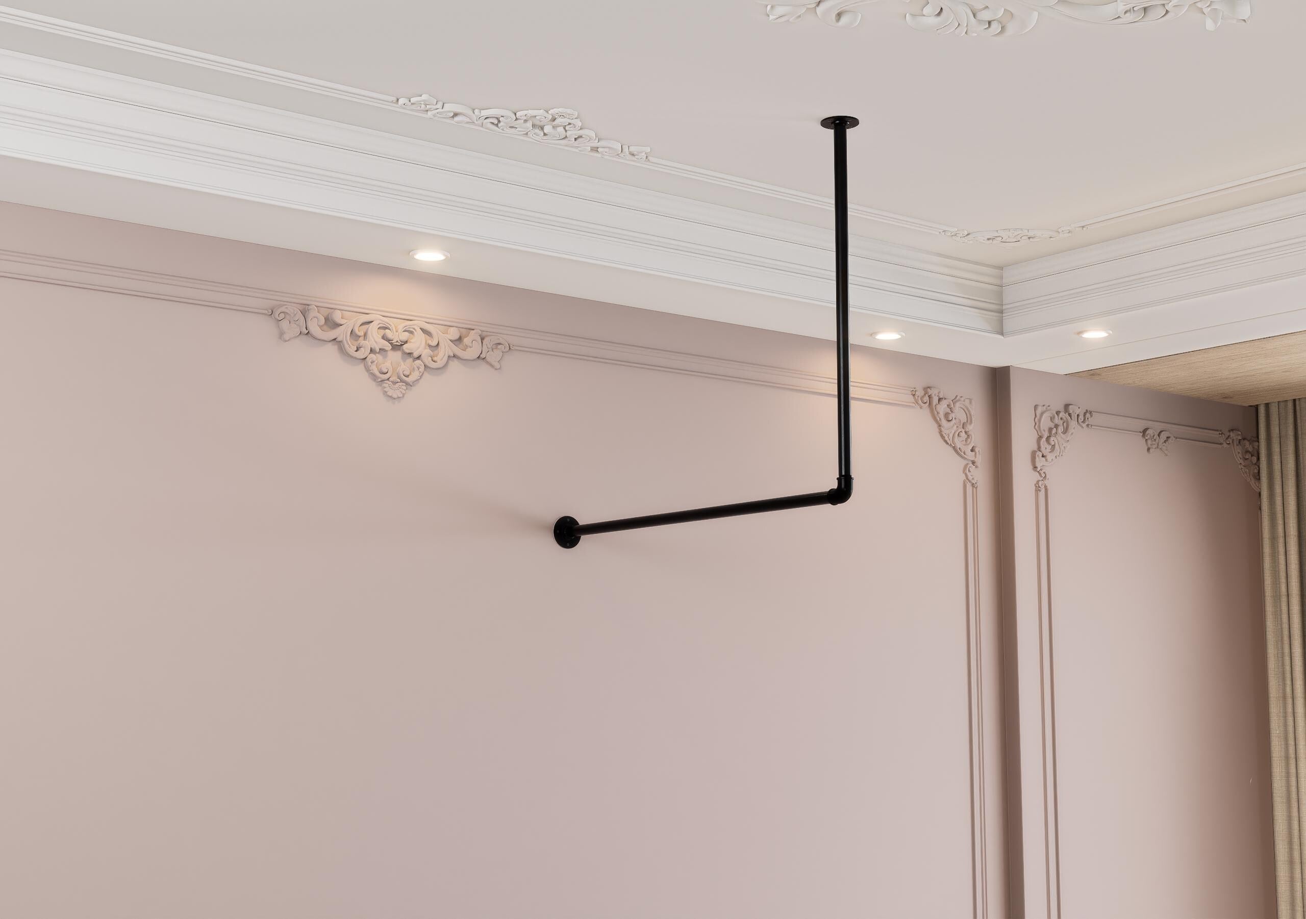 a room with a pink wall and a black pipe