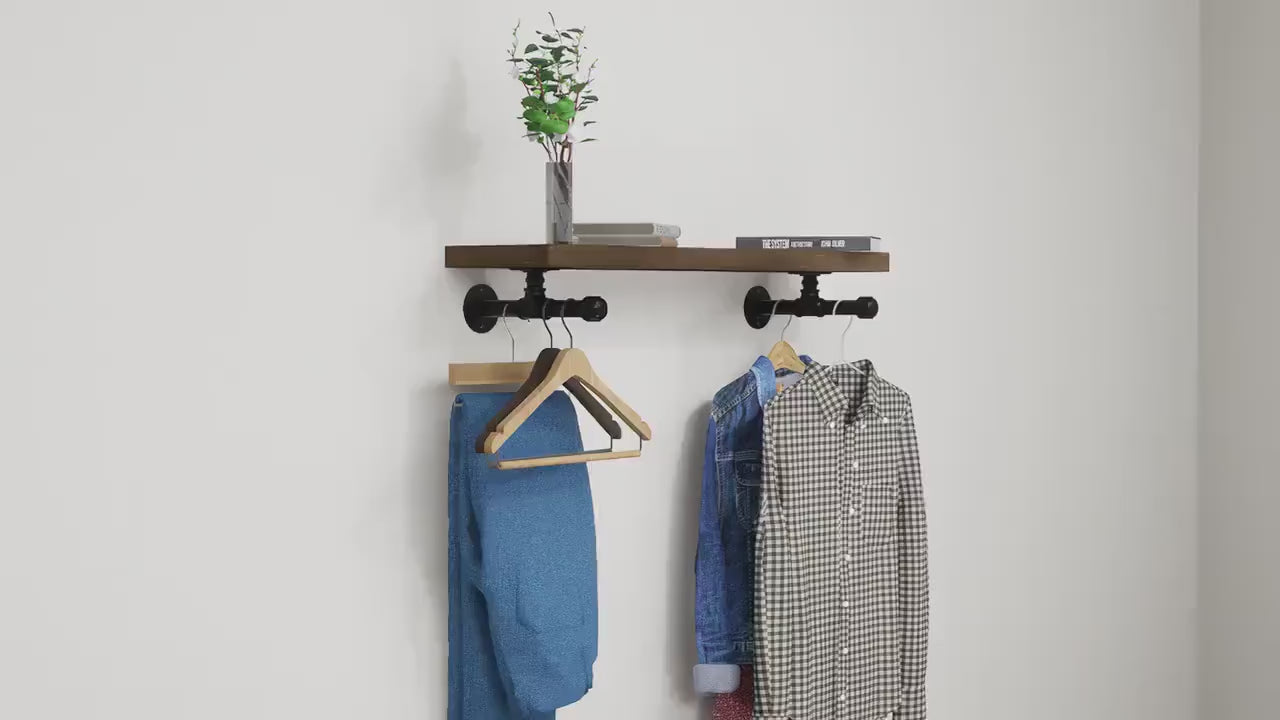Load video: Wall-mounted industrial shelf with a wooden shelf and metal pipe fittings, featuring a hanging rail for clothes storage.