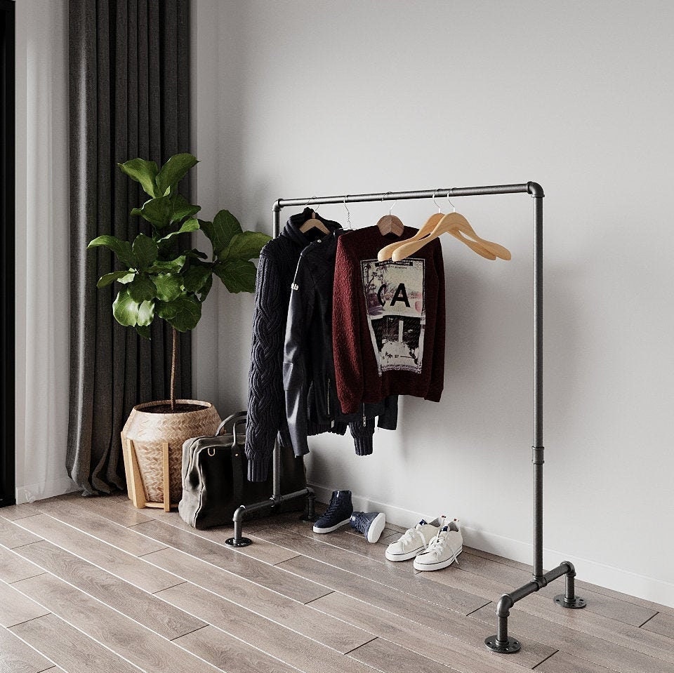 Portable and Collapsible Pipe Clothes Rail, a freestanding rack with hanging garments, highlighting its convenient and space-efficient design.